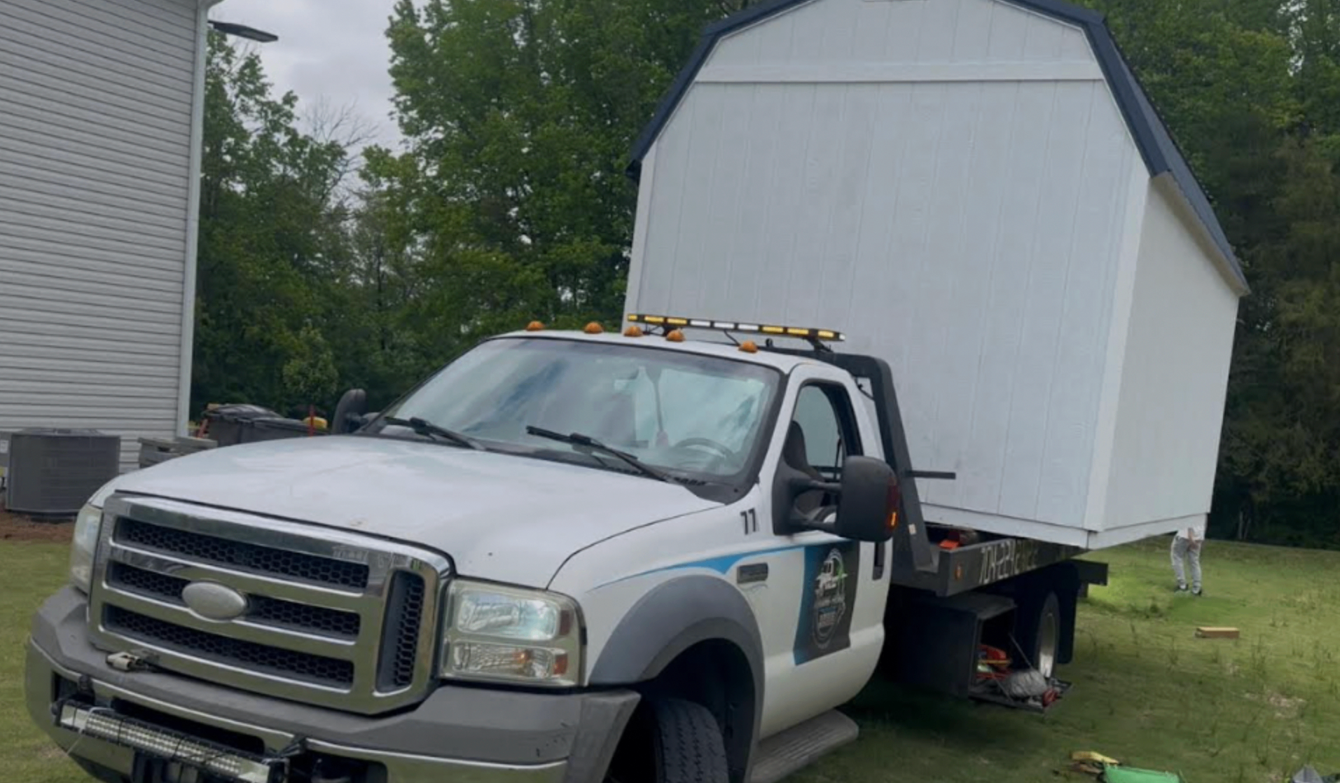 Towing Frogs flatbed hauling a shed