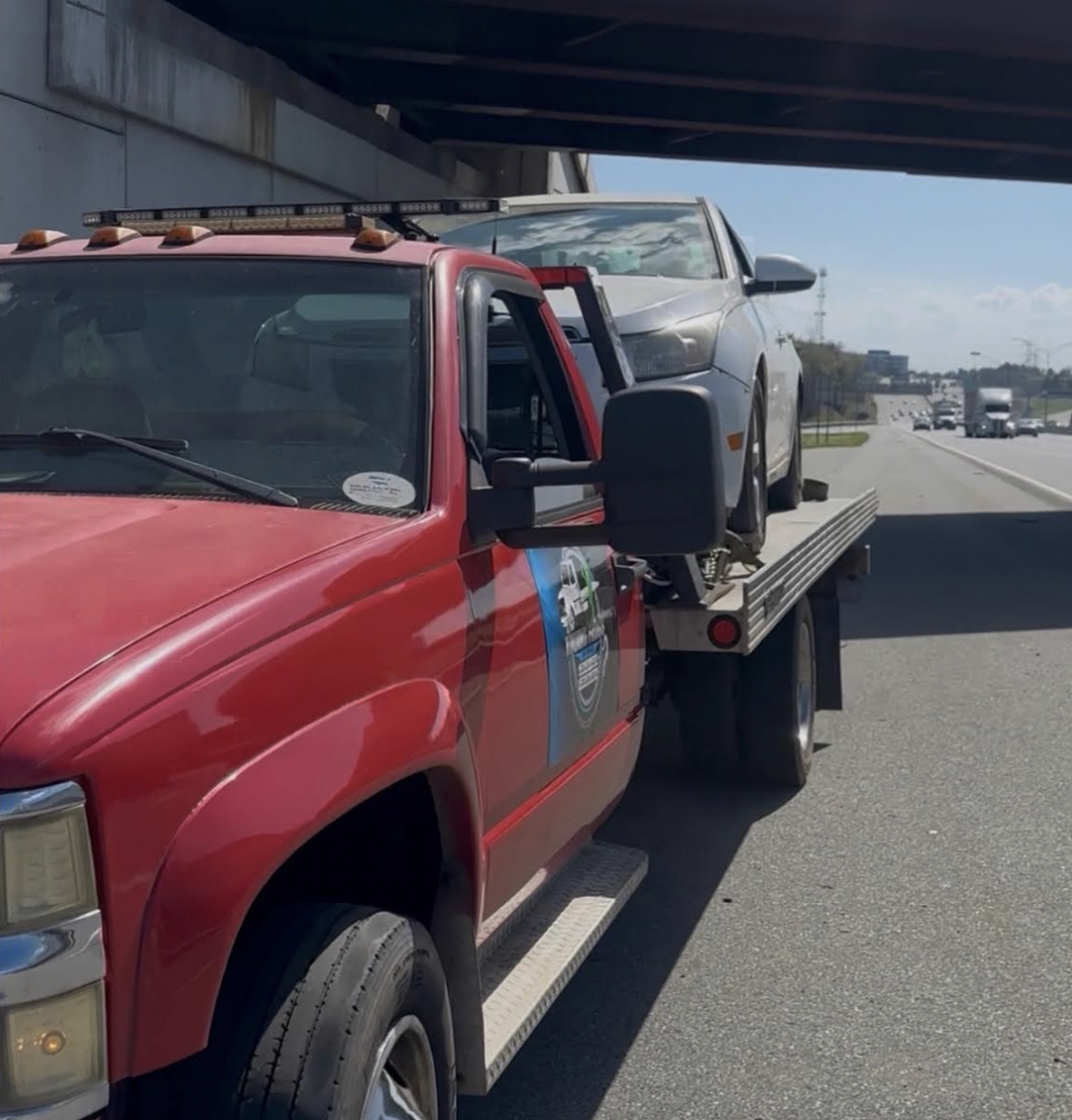 Towing Frogs red flatbed hauling a sedan